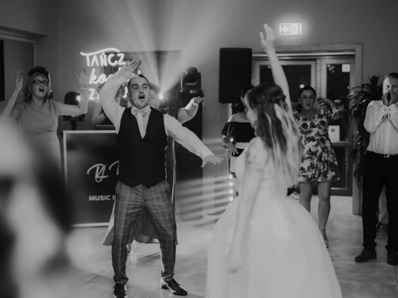 Taniec z panną młodą pod neonem, zdjęcie czarno-białe